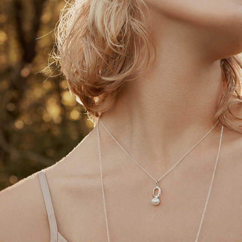 Oval shaped gold pendant necklace with freshwater pearl