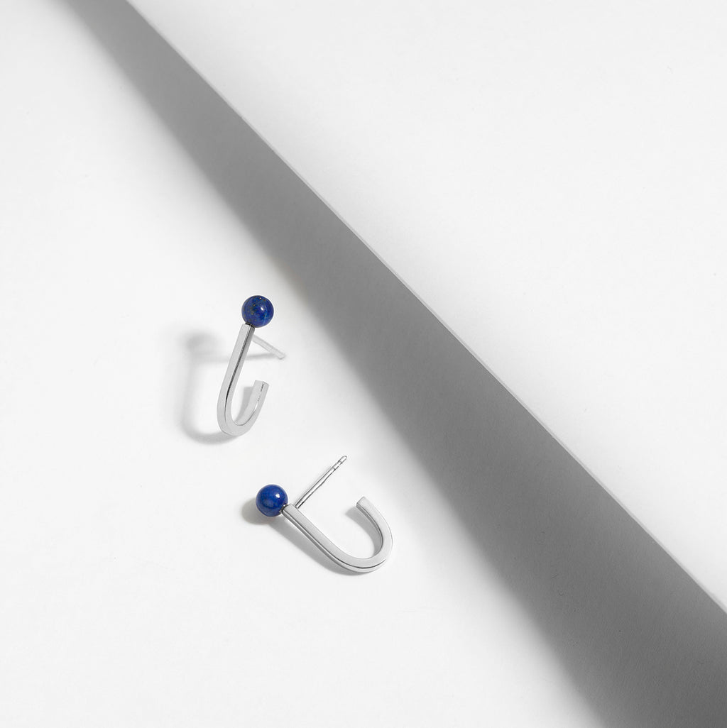 Small J shaped line earrings that hug the ear in silver and lapis lazuli
