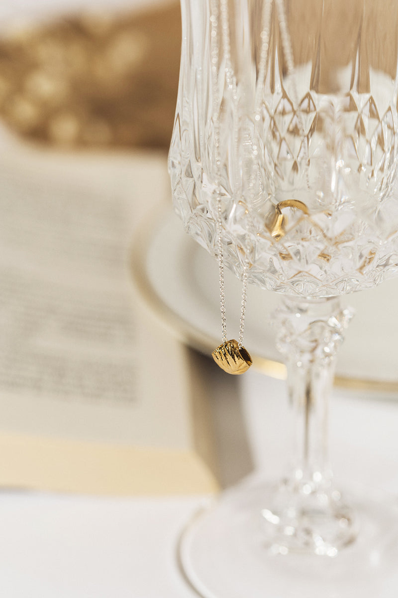 Small gold pendant on a delicate silver chain