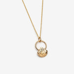 Open circle gold necklace with geometric dangling charm